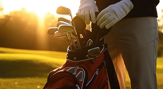 Golfer holding golf bag on course