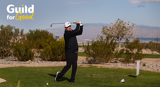 Guild employee hitting golf ball