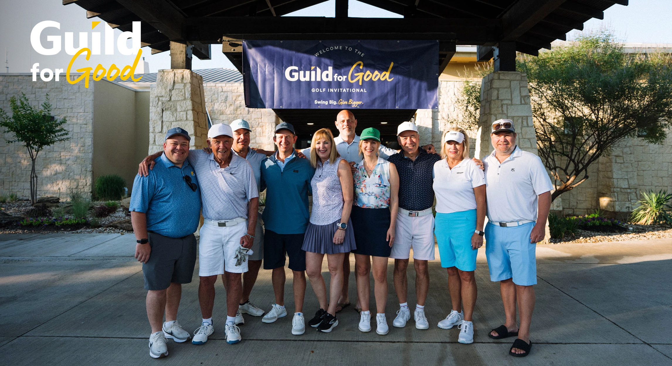Golf tournament participants gather for a group photo under the Guild for Good Golf Invitational welcome banner.